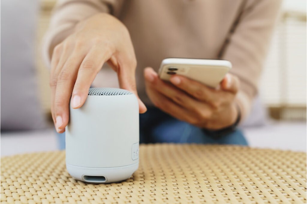 Pessoa conectando o celular a uma caixa de som bluetooth