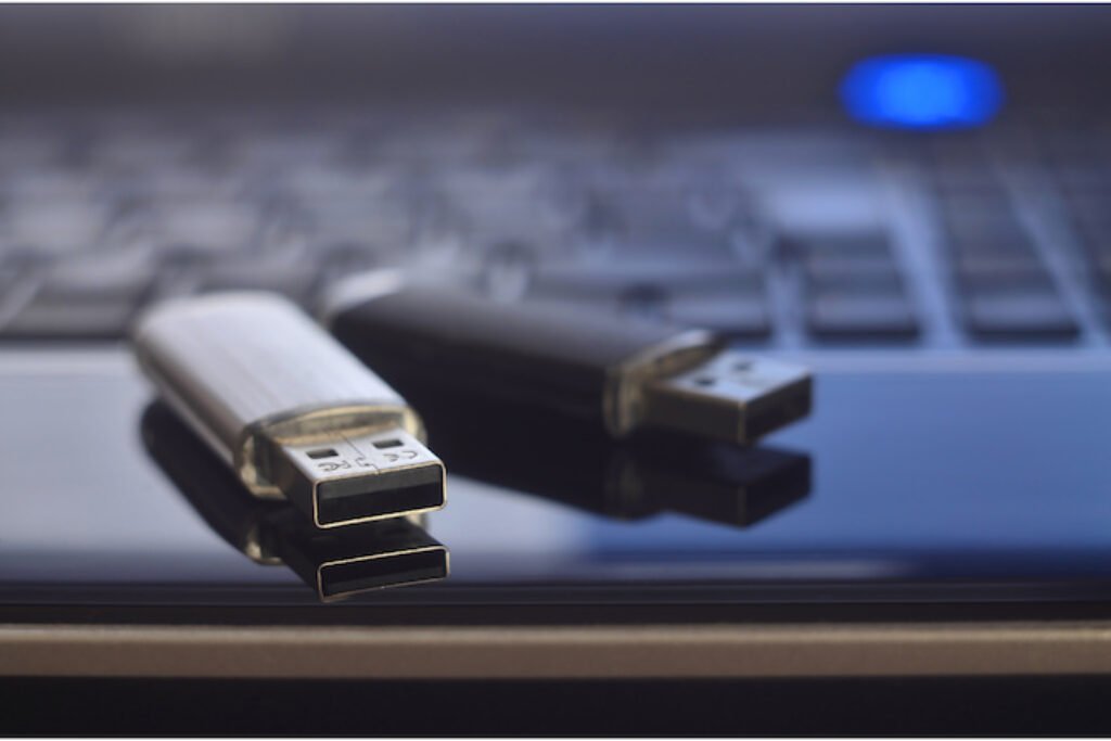 Foto dois pen drives em cima de um notebook