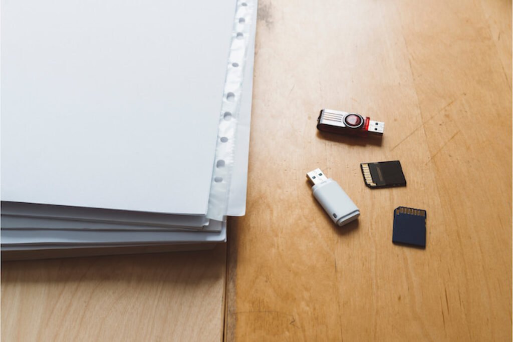 foto papéis, pen drive e cartões de memória em uma mesa