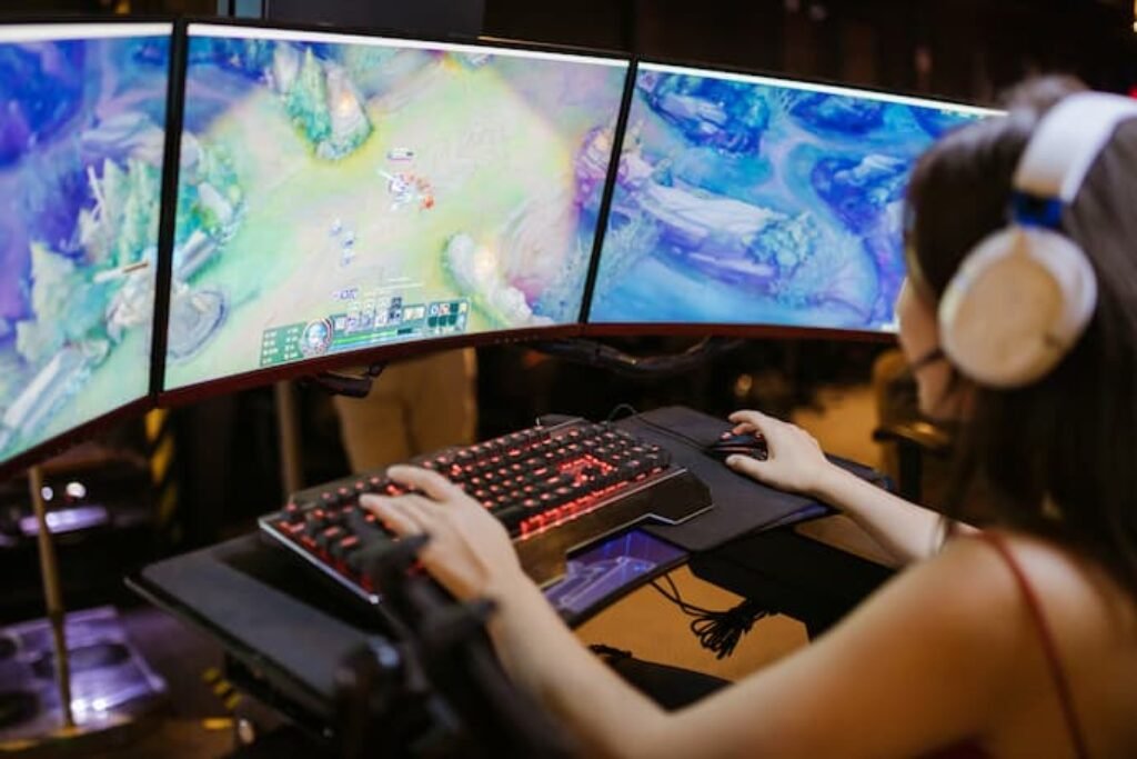 mulher jogando em 3 monitores