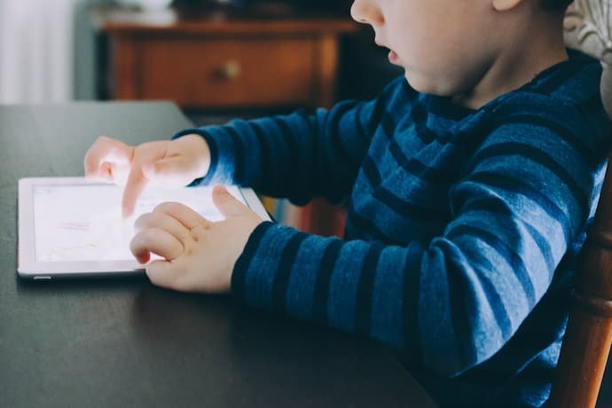 Criança usando o tablet na sala