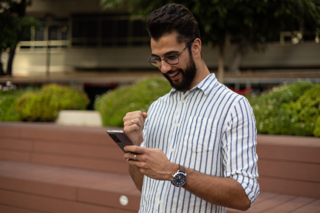 Homem feliz usando um celular.