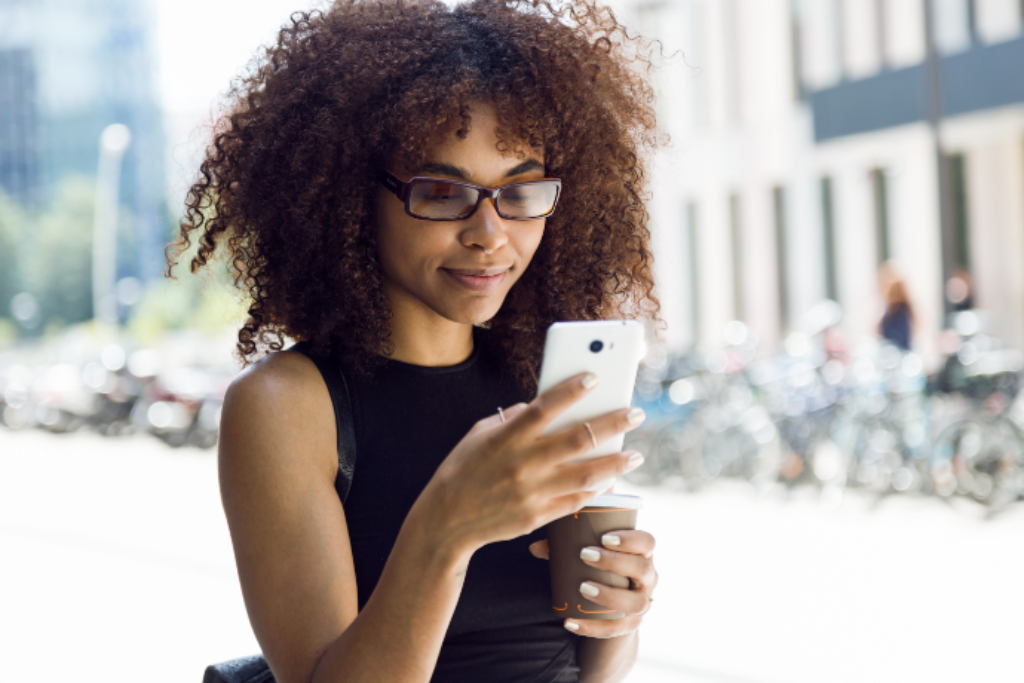 Mulher usando o celular na rua.